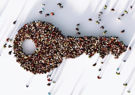 Human crowd forming a big key icon on white background.