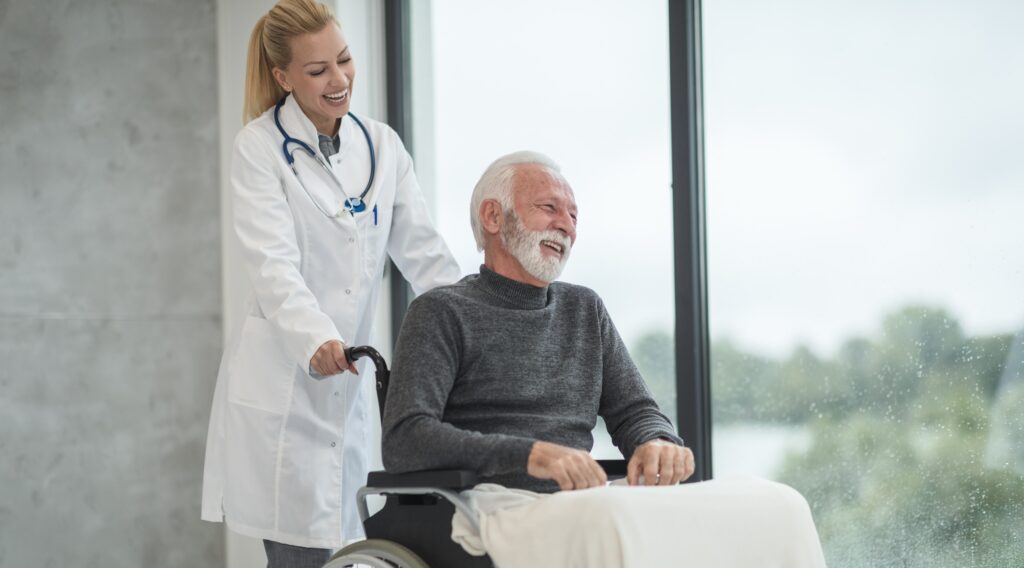 Nursing home patient laughing with clinician.