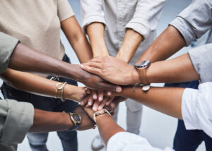 Group of hands stacked to represent teamwork.