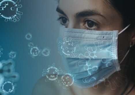 A woman wearing a face mask with virus graphics floating around.