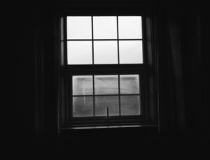 A simple window in a dark room representing isolation.