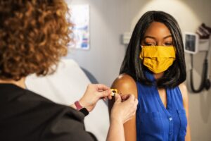 Woman getting a band aid after a vaccine.