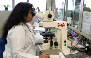 Lab technician using a microscope.