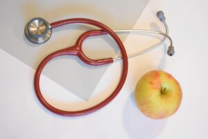 Stethoscope and apple on a table.