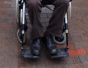 Man's legs sitting in wheelchair.