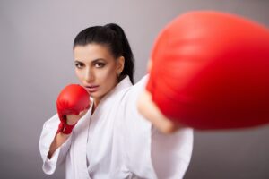 Woman in fighting stance with fighting gear on.