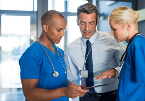 Medical team interacting using digital tablet at modern hospital.