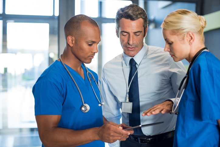 Medical team interacting using digital tablet at modern hospital.