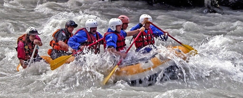 Group of people white water rafting.