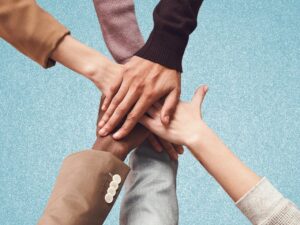 Hands piled on top of each other to represent building relationships.