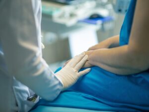 A caring doctor-patient moment. The doctor is setting their hand on the patient's hand.