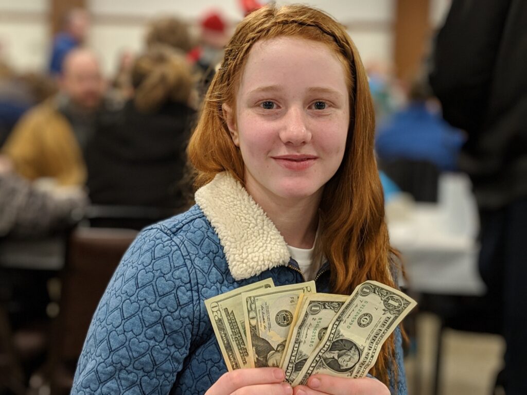 Teenage girl holding a donation at a fundraising event.